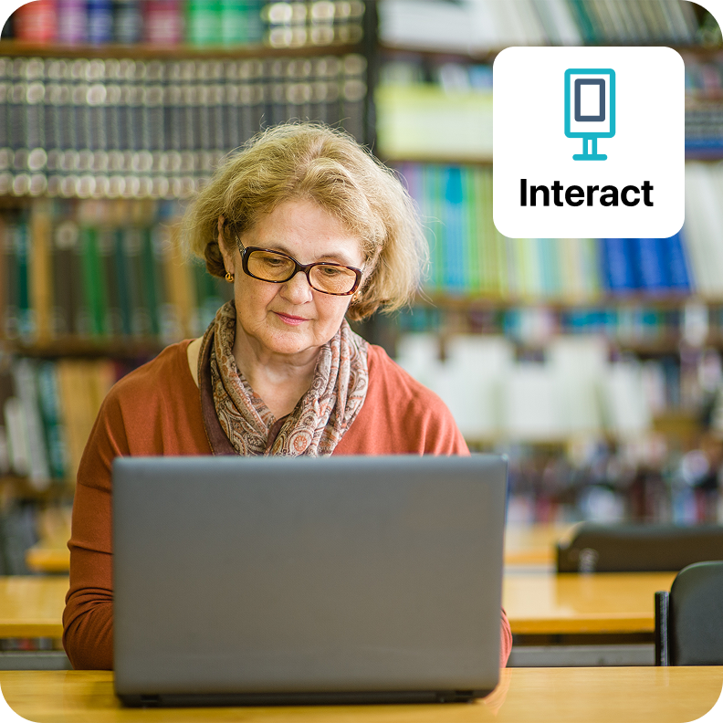 image of staff member working at a computer in a library